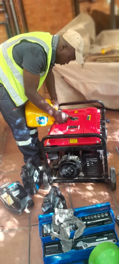Technician topping up a portable generator during preventative maintenance